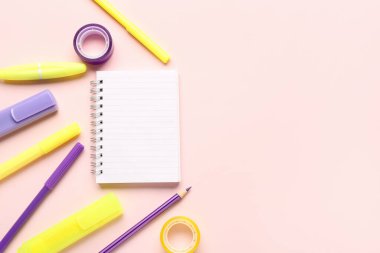 Pembe arka planda farklı okul kırtasiyesine sahip defter.