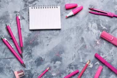 Grunge blue arkaplan üzerinde farklı kırtasiye malzemesi olan defter