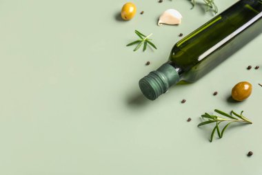 Yeşil arka planda bir şişe zeytinyağı.