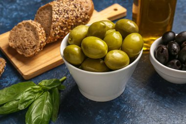 Mavi arka planda olgun zeytinli kaseler