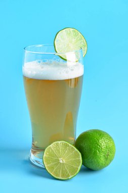 Mavi arka planda limonlu soğuk bira.