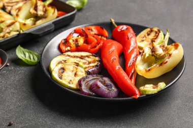 Siyah arka planda lezzetli ızgara sebzeli tabak.