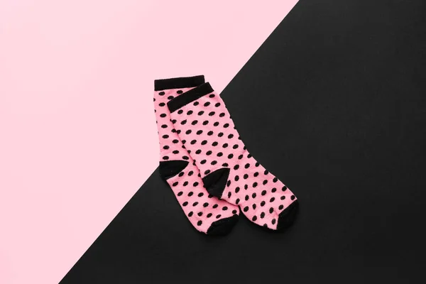 stock image Pair of pink socks on color background