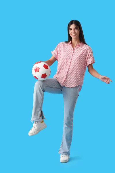 Ung Kvinna Som Leker Med Fotboll Blå Bakgrund — Stockfoto