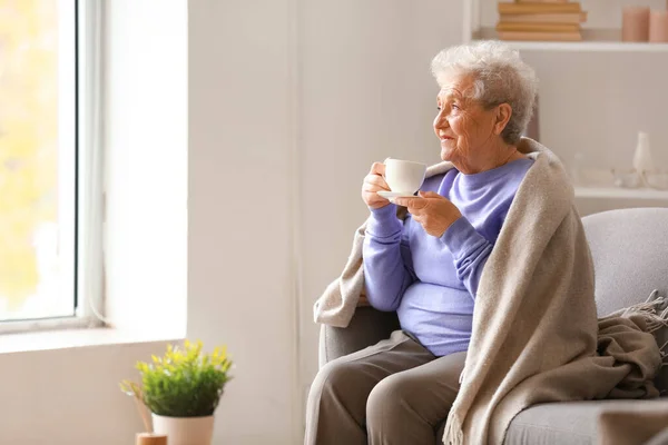 Seniorin Mit Plaid Trinkt Kaffee Auf Sofa Hause — Stockfoto