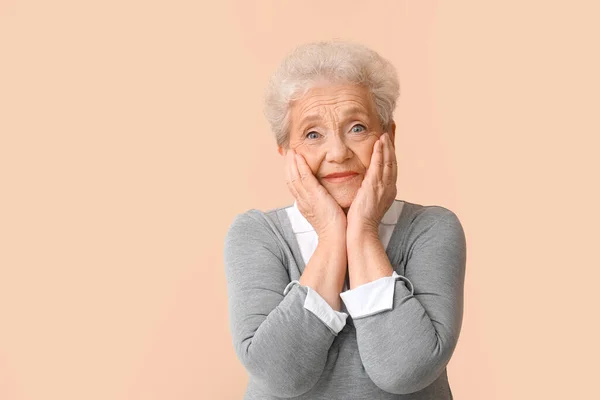 Überraschte Seniorin Auf Beigem Hintergrund — Stockfoto