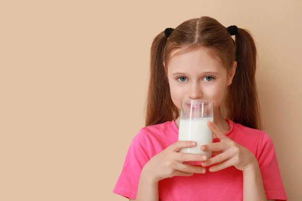 带着米色背景的牛奶的小女孩 — 图库照片
