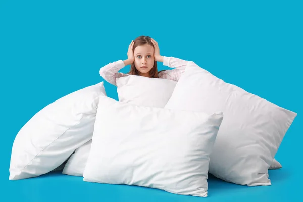 Şok Olmuş Küçük Kız Mavi Arka Planda Bir Sürü Yastıkla — Stok fotoğraf