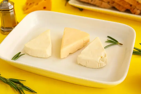 Sarı Zemin Üzerinde Lezzetli Işlenmiş Peynir Üçgenleri Olan Bir Tabak — Stok fotoğraf