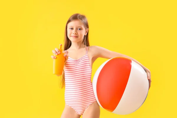 Meisje Met Fles Zonnebrandcrème Opblaasbare Bal Gele Achtergrond — Stockfoto