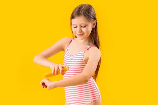 Маленька Дівчинка Наносить Сонцезахисний Крем Жовтий Фон — стокове фото