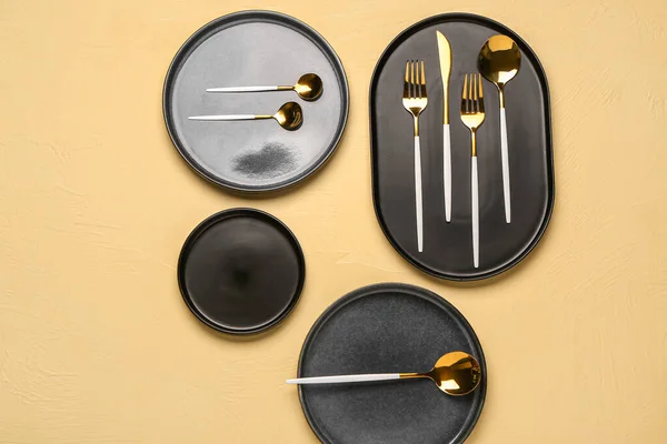 Καθαρίστε Μαύρα Πιάτα Χρυσά Μαχαιροπίρουνα Κίτρινο Τραπέζι — Φωτογραφία Αρχείου