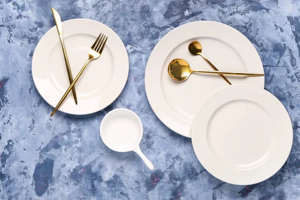 Καθαρίστε Πιάτα Σετ Από Χρυσά Μαχαιροπίρουνα Μπλε Τραπέζι Grunge — Φωτογραφία Αρχείου