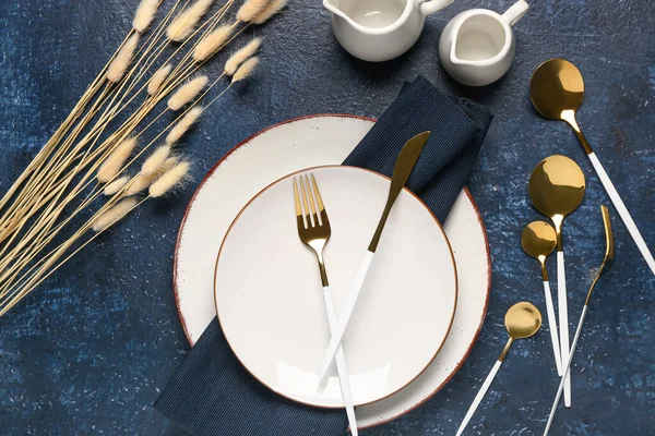 Table Setting Clean Plates Golden Cutlery Dried Lagurus Blue Background — Stock Photo, Image