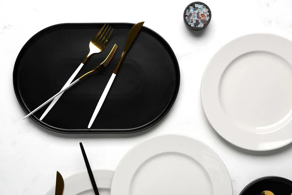 Tischdecken Mit Sauberen Tellern Und Goldenem Besteck Auf Weißem Hintergrund — Stockfoto