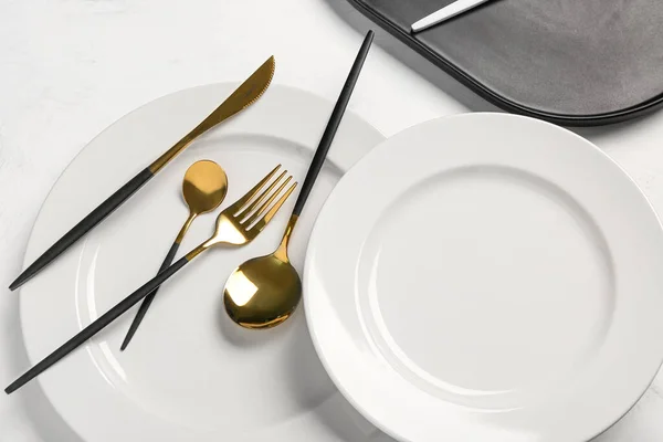 Tischdecken Mit Sauberen Tellern Und Goldenem Besteck Auf Weißem Hintergrund — Stockfoto