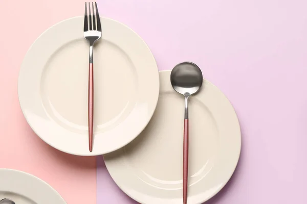 粉红和紫丁香背景上有餐具的干净盘子 — 图库照片