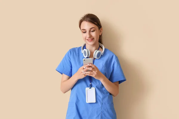 Női Orvosi Gyakornok Mobiltelefonnal Bézs Alapon — Stock Fotó