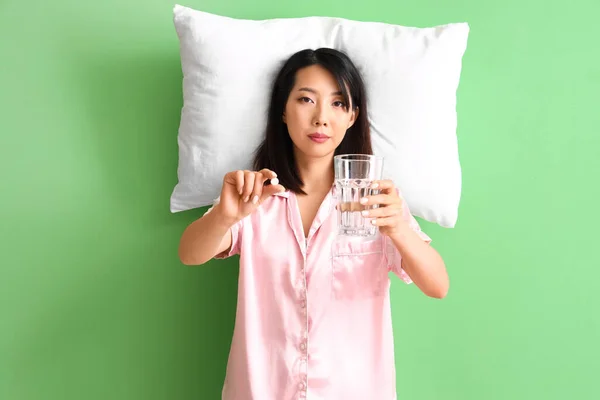 Piękna Azjatka Piżamie Szklanką Wody Pigułką Zielonym Tle — Zdjęcie stockowe