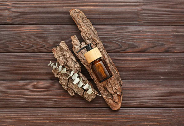 Bottle Cosmetic Oil Eucalyptus Twig Tree Bark Brown Wooden Background — Stock Photo, Image