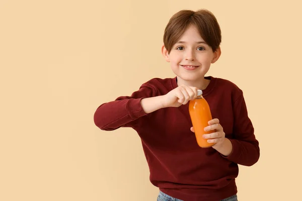 Mały Chłopiec Butelką Soku Pomarańczowego Beżowym Tle — Zdjęcie stockowe