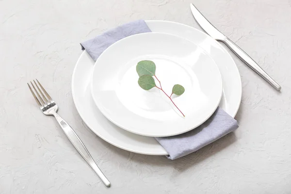 Schöne Tischdekoration Mit Sauberem Teller Besteck Und Eukalyptuszweig Auf Grauem — Stockfoto