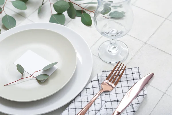 Schöne Tischdekoration Mit Leerer Einladungskarte Und Eukalyptuszweigen Auf Weiß Gefliestem — Stockfoto