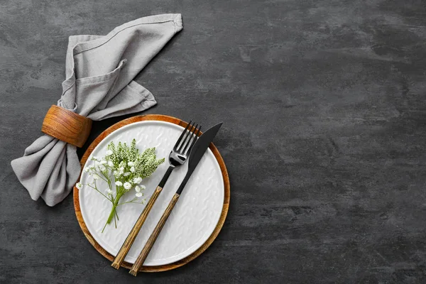 Çatal bıçak takımı ve siyah masa üzerinde çingene çiçekleri olan güzel bir masa.