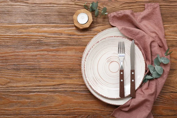 stock image Beautiful table setting with eucalyptus branches and candle on wooden table