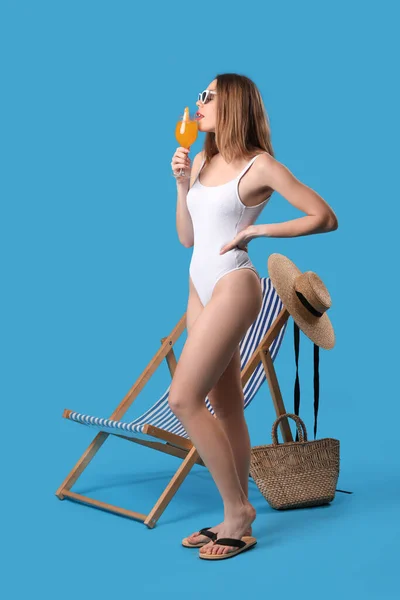 Mavi Arka Planda Kokteyli Olan Mayo Giymiş Genç Bir Kadın — Stok fotoğraf