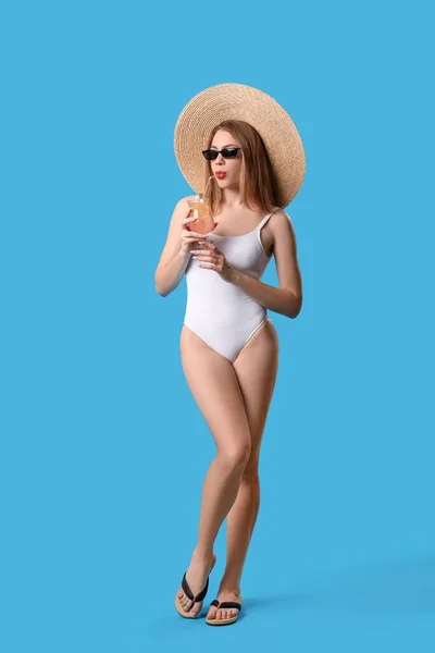 Junge Frau Badeanzug Trinkt Cocktail Auf Blauem Hintergrund — Stockfoto