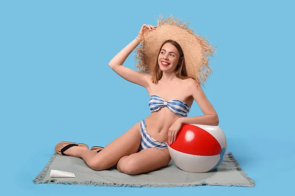 Młoda Kobieta Stroju Kąpielowym Piłką Plażową Siedząca Niebieskim Tle — Zdjęcie stockowe