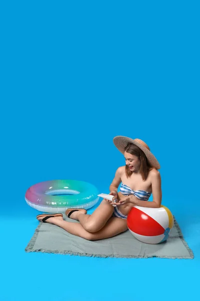 Junge Frau Badeanzug Trägt Sonnencreme Auf Blauem Hintergrund Auf — Stockfoto