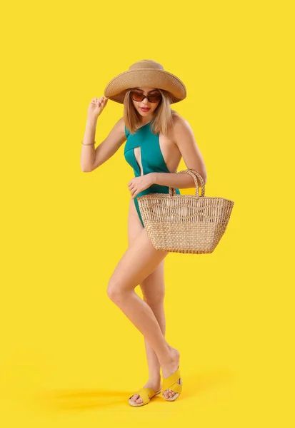 Młoda Kobieta Stroju Kąpielowym Torbą Żółtym Tle — Zdjęcie stockowe