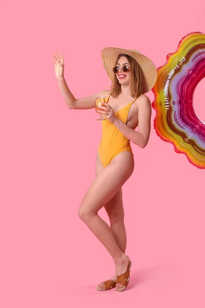 Pembe Arka Planda Kokteyli Olan Mayo Giymiş Genç Bir Kadın — Stok fotoğraf