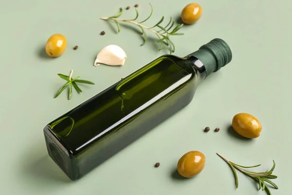 緑の背景にオリーブオイルのボトル — ストック写真