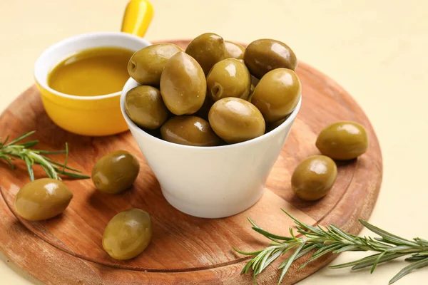 Olgun zeytinli kaseler ve sarı arka planda yağ