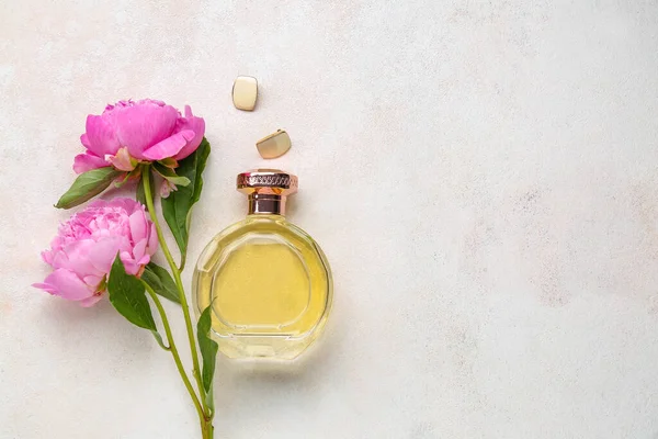 浅色背景的香水瓶 耳环和美丽的牡丹花 — 图库照片