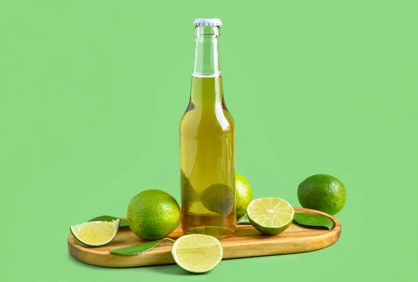 緑の背景にライムと冷たいビールのボトル — ストック写真