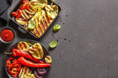 Siyah arka planda lezzetli ızgara sebzeli tabak ve fırın tabağı.