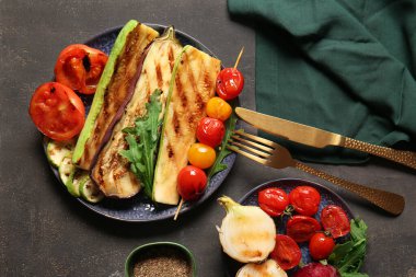 Koyu arkaplanda lezzetli ızgara sebzeli tabaklar.