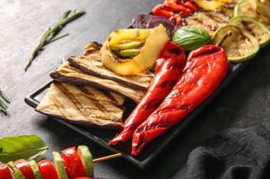 Siyah arka planda lezzetli ızgara sebzeli tabak.