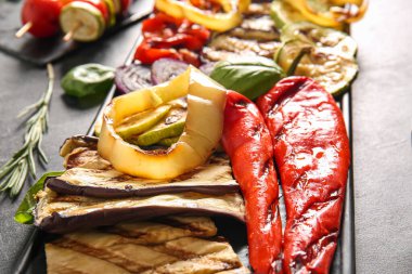 Siyah arka planda lezzetli ızgara sebzeli tabak.