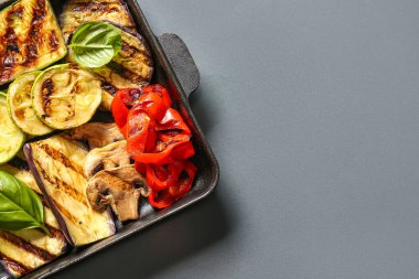 Koyu arkaplanda lezzetli ızgara sebzeli fırın yemeği.