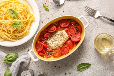 Lezzetli domatesli fırın tabağı, beyaz arka planda beyaz peynir ve makarna.