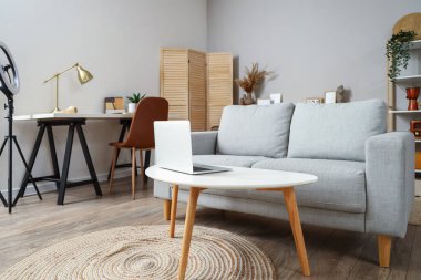 Oturma odasının içinde kanepe ve işyeri var.