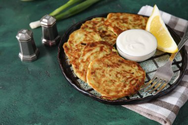Yeşil arka planda lezzetli kabaklı börek tabağı.