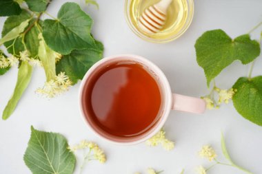 Gri arkaplanda bal ve ıhlamur çayı.