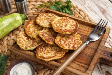 Hafif ahşap arka planda ekşi kremalı lezzetli kabaklı börek.