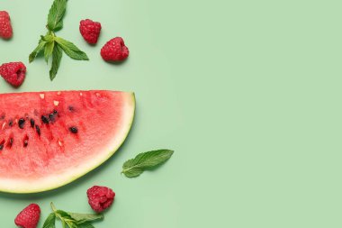 Yeşil arka planda taze karpuz ve ahududu.